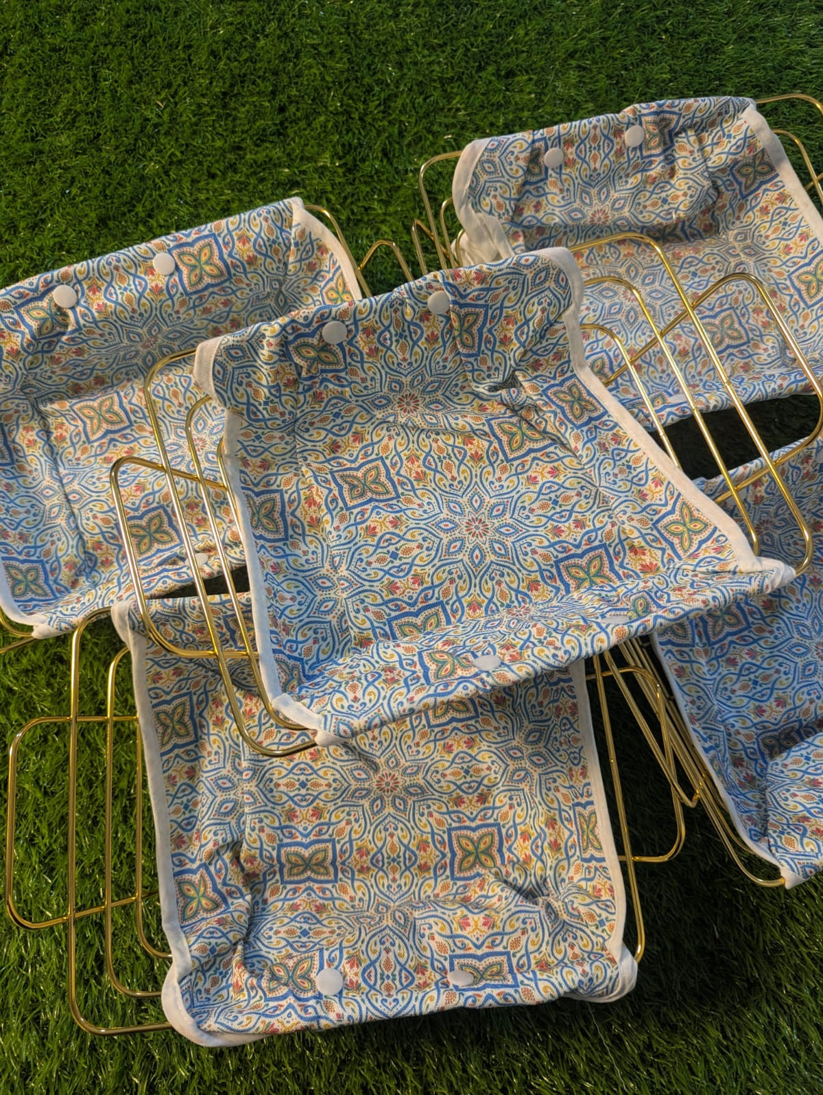 Golden metal bread basket with colourful patterned fabric liner