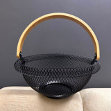 Empty round black wire mesh fruit basket with wooden handle
