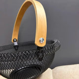 Close-up of wooden handle and black metal mesh on fruit basket
