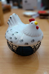 Large white speckled hen-shaped decorative lid on black metal wire egg basket, farmhouse kitchen storage